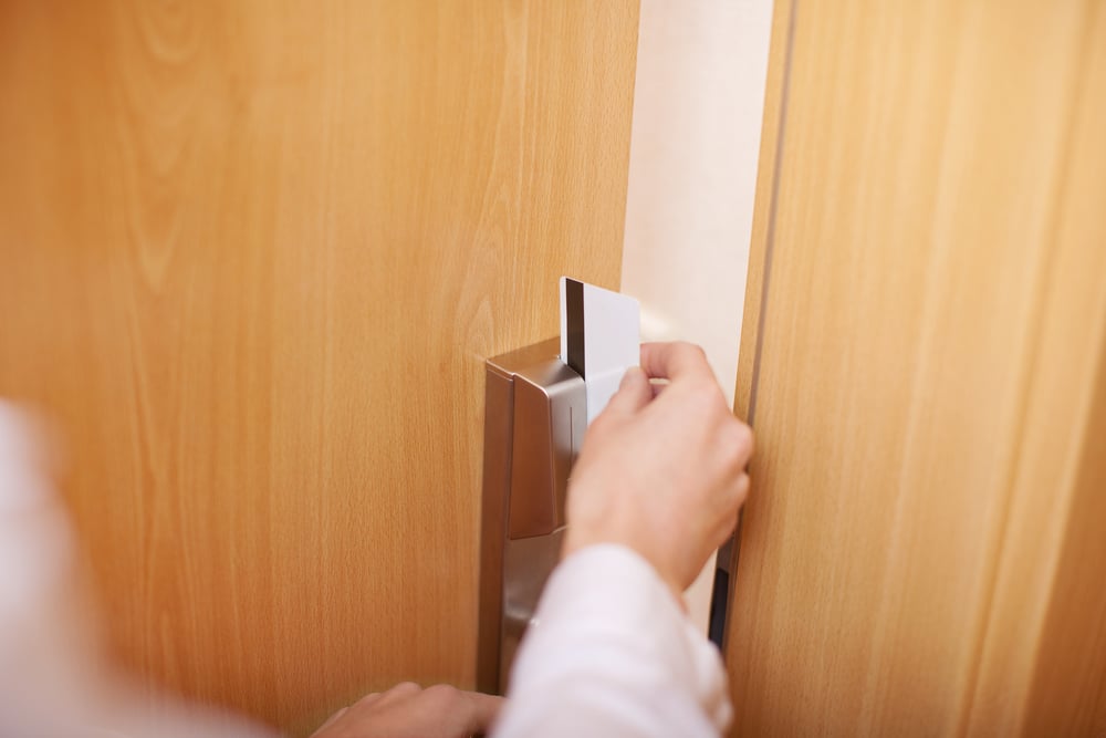 a photo of someone opening a hotel door with a keycard