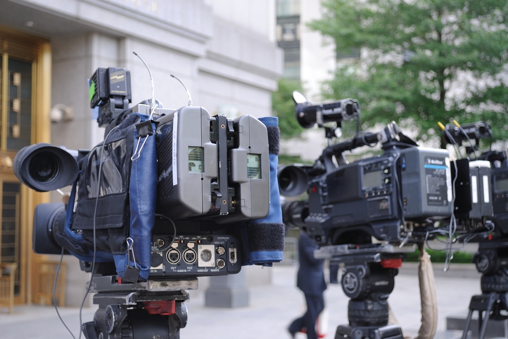 Cameras from tv reporters facing a building